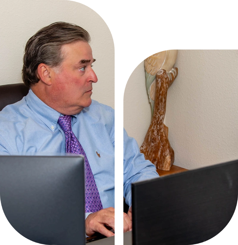 Man in blue shirt working on laptop.